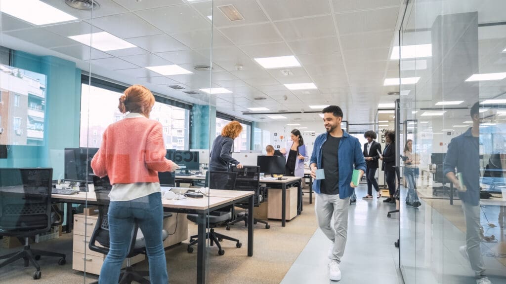 Office scene with people and computers, illustrating issues with Cat B fit outs not aligning with team workflows.